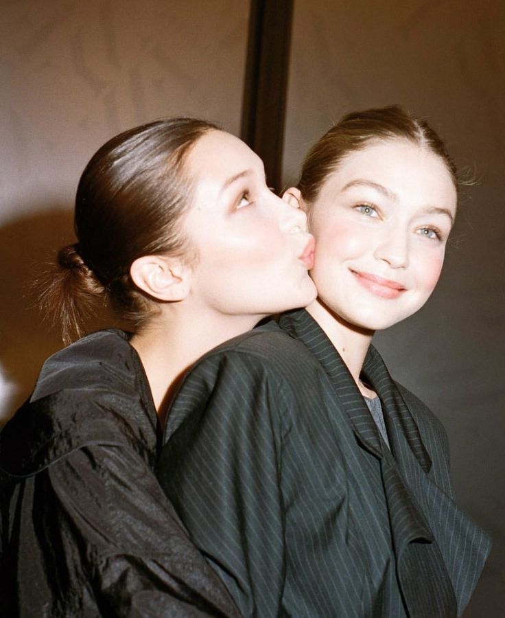 two women are kissing each other in black and white