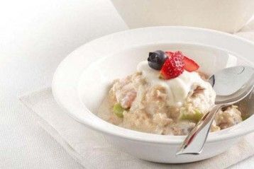 a bowl filled with oatmeal and fruit on top of a white napkin