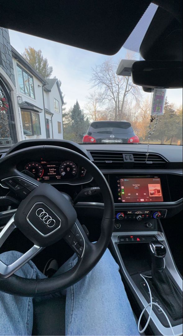 the interior of an audi car is shown in front of a house with cars parked on the street