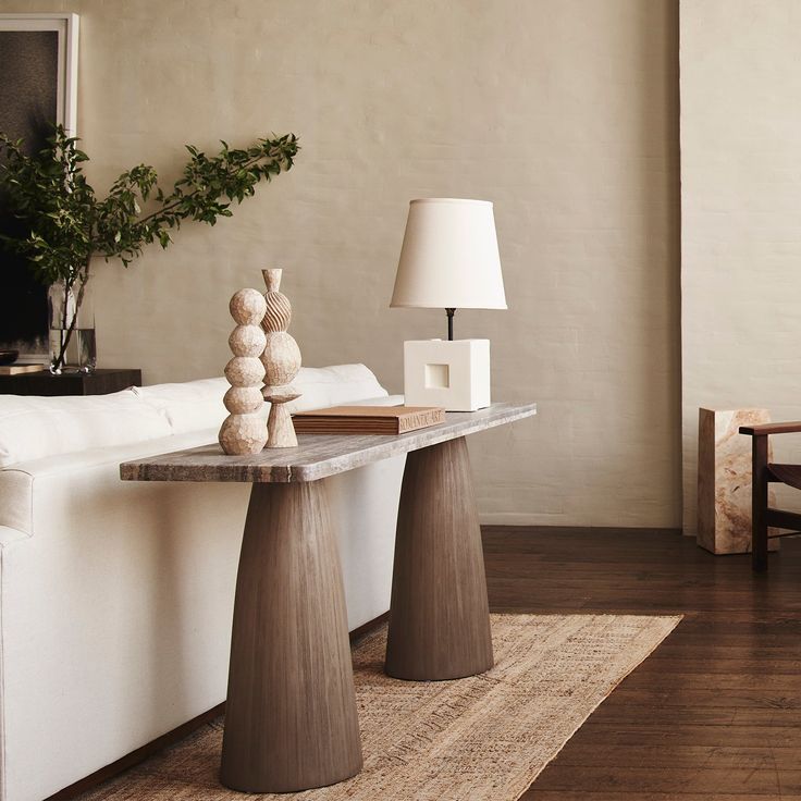 a white couch sitting next to a wooden table on top of a hard wood floor