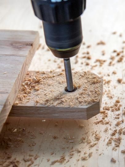 a drill is being used to remove wood shavings from a piece of wood