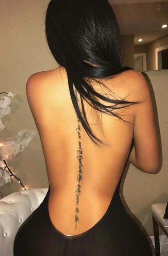 the back of a woman's body with tattoos on it