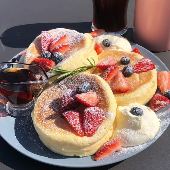 pancakes with berries and powdered sugar on a plate