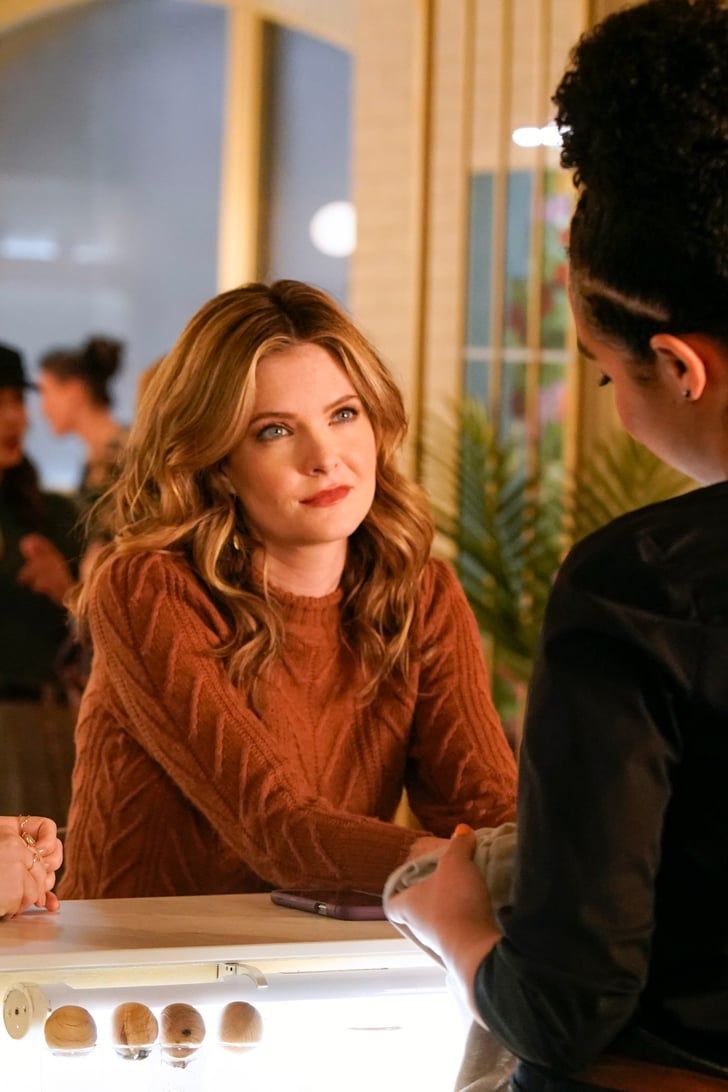 two women are sitting at a table talking