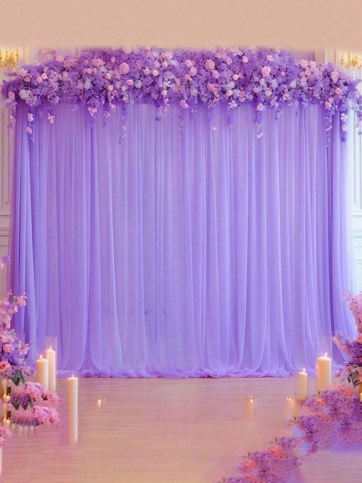 a purple backdrop with flowers and candles