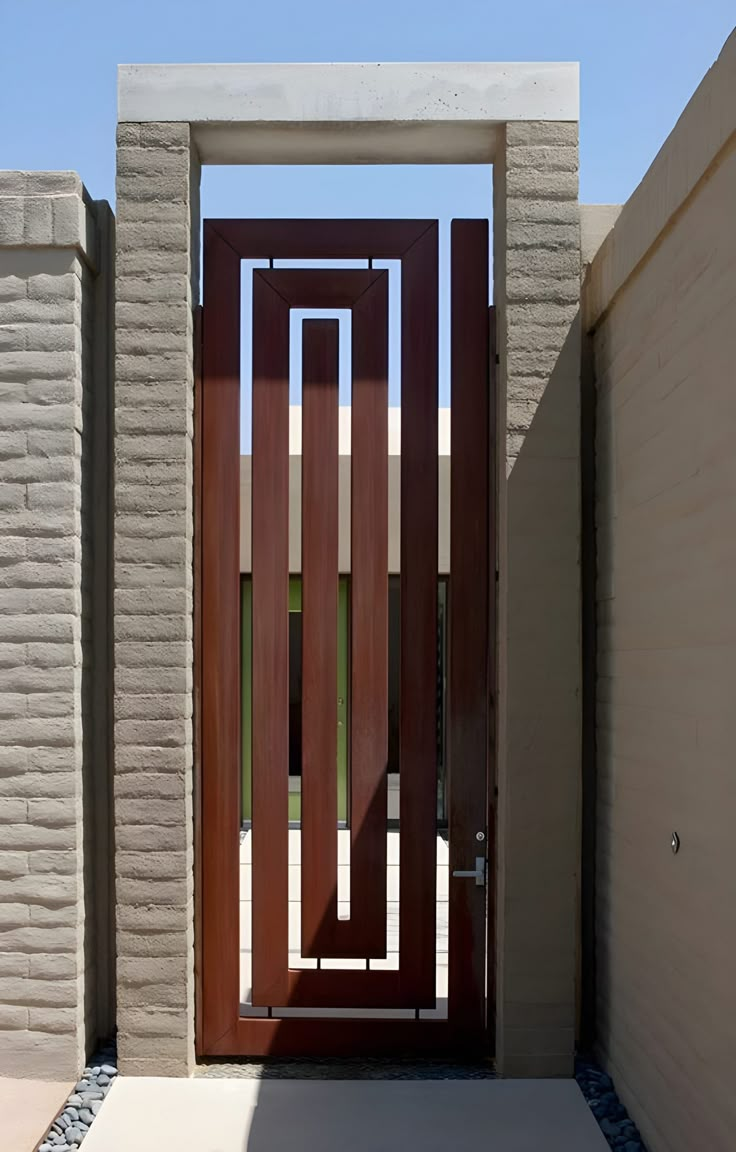 an entrance to a home with brick walls and wooden doors, surrounded by stone pillars