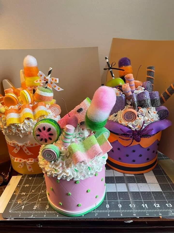 two colorful baskets filled with candy and candies sitting on top of a cutting board