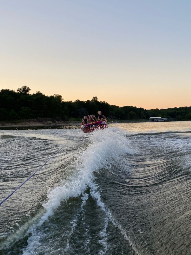 a group of people riding on the back of a boat in the middle of water