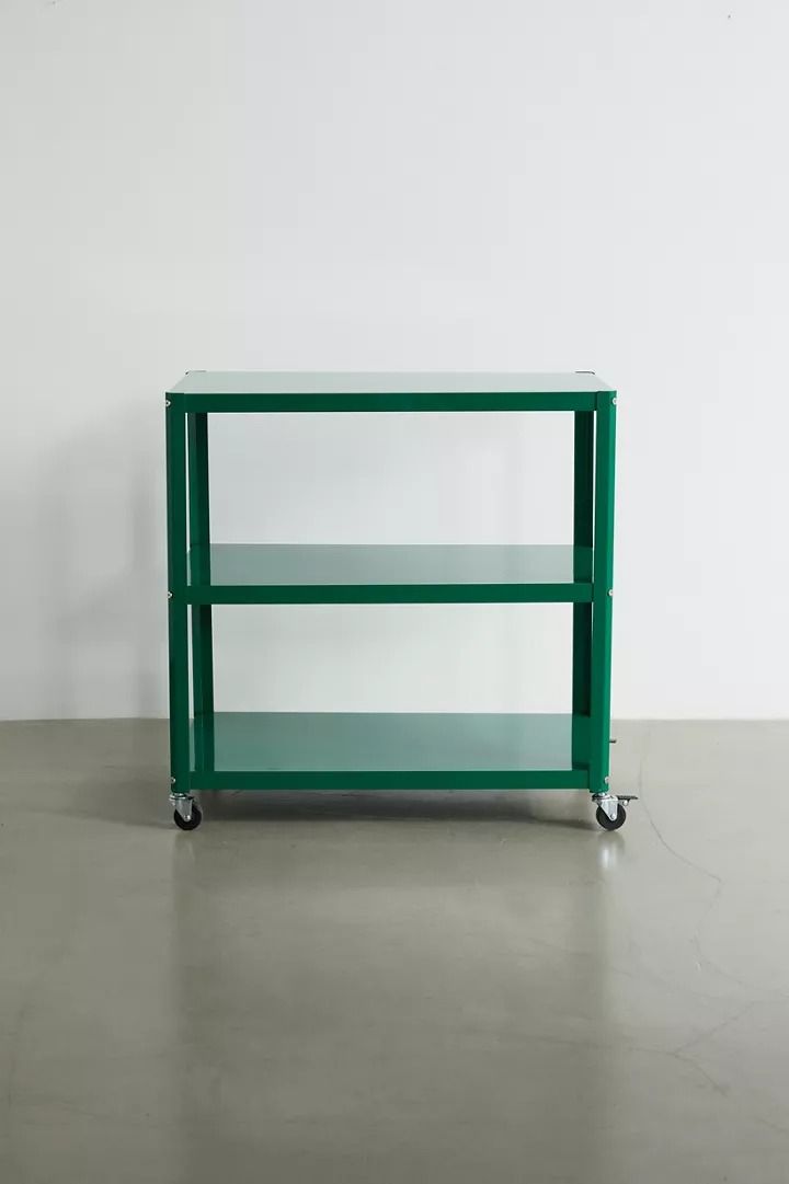 a green shelf sitting on top of a cement floor