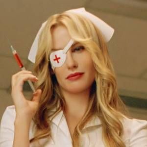 a woman in scrubs and eye patch holding a syringe