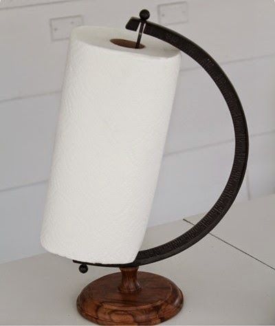 a white toilet paper roll on top of a wooden stand with a black ring around it