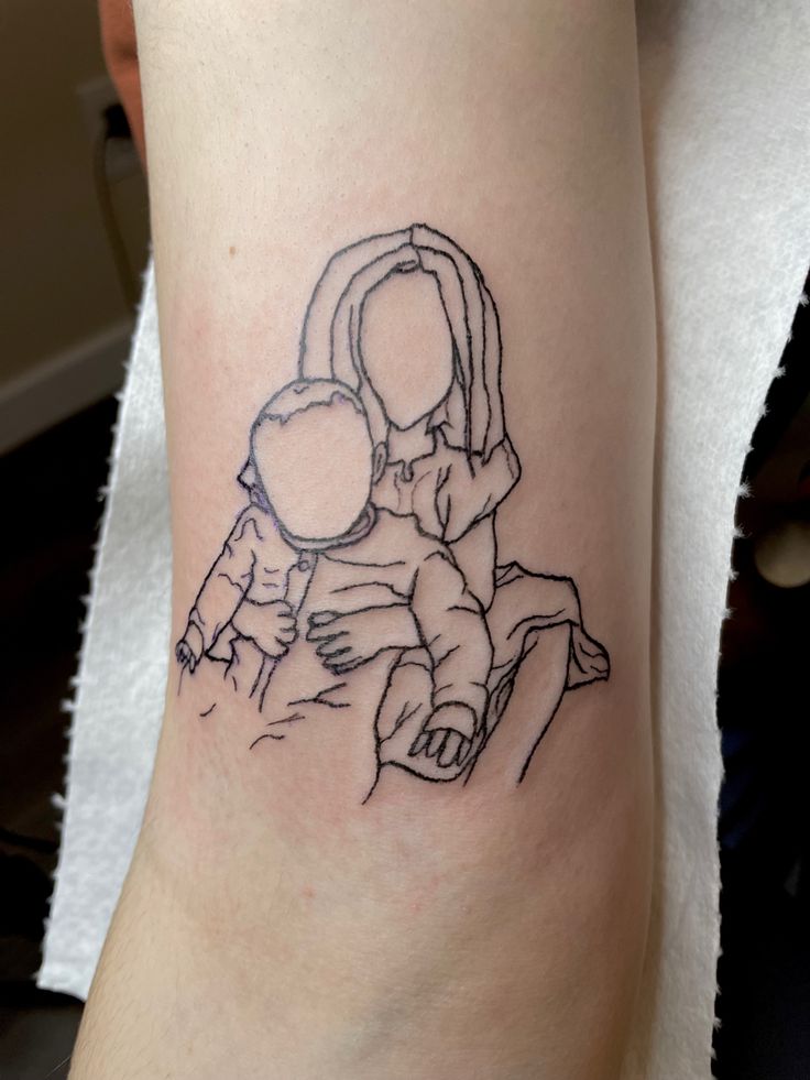 a woman with a child tattoo on her leg is holding the baby in her arms