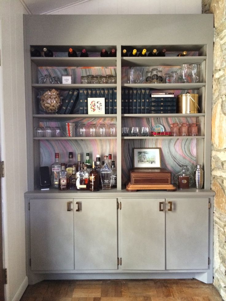 a bookcase filled with lots of bottles and glasses