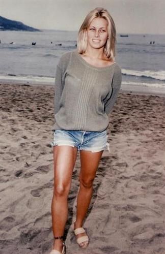 a woman standing on top of a sandy beach