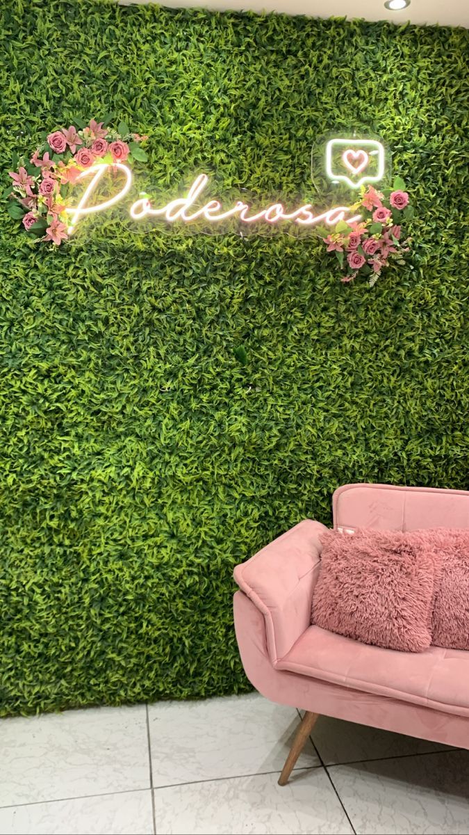 a pink couch sitting in front of a green wall