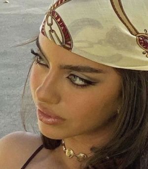 a close up of a woman wearing a head piece with jewelry on her neck and face