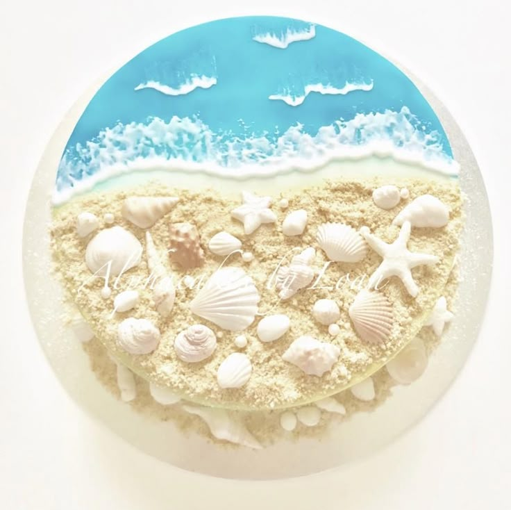 there is a cake decorated with seashells on the beach