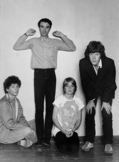 three men and two women posing for a black and white photo with their arms in the air