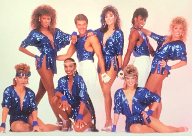 a group of women in blue and white outfits posing for a photo with their hands on their hips