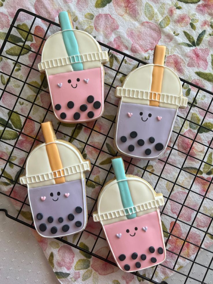 three decorated cookies sitting on top of a cooling rack