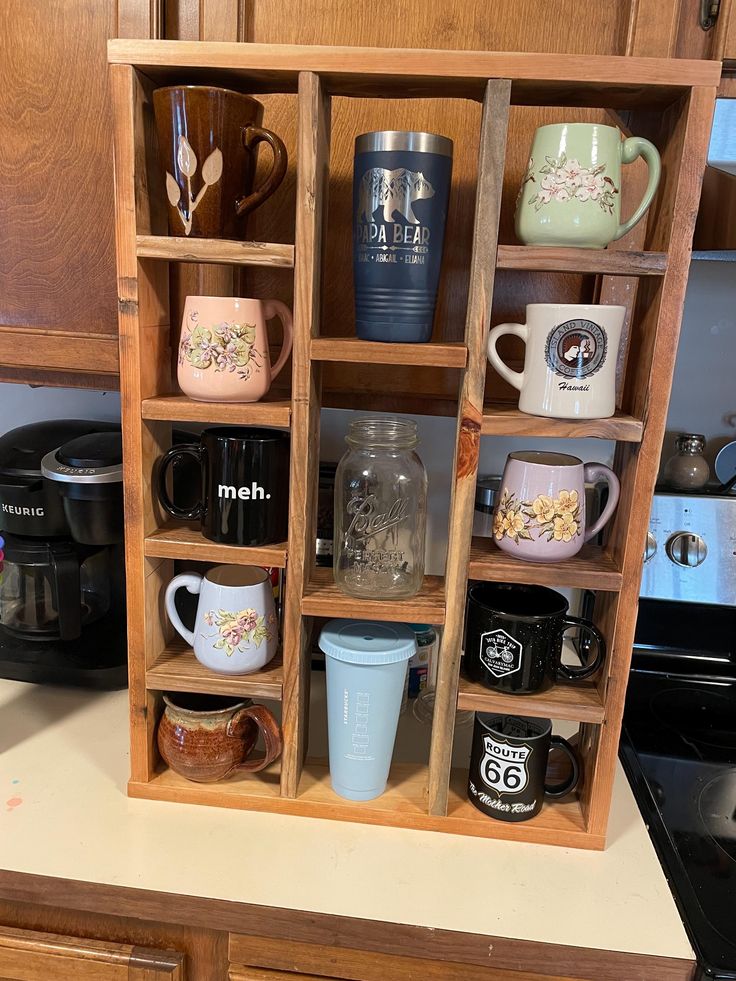 a wooden shelf filled with coffee cups and mugs on top of a kitchen counter