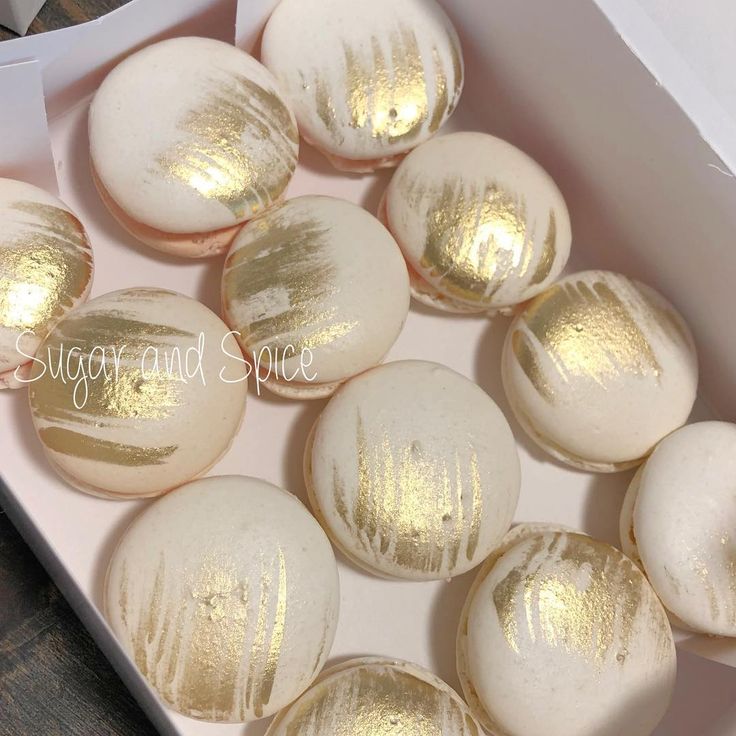 some white and gold decorated cookies in a box