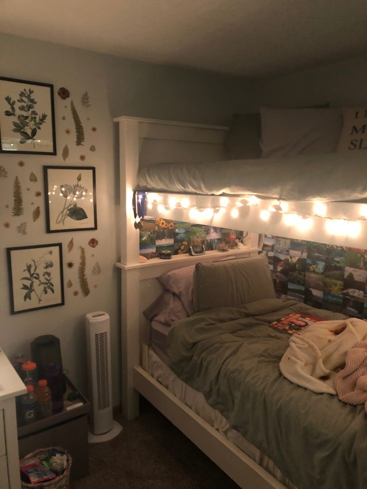 a bedroom with lights strung above the bed and pictures on the wall over the headboard