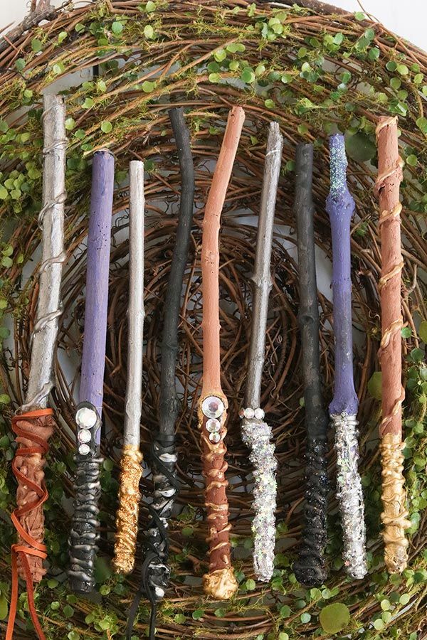 a bunch of different colored candles sitting on top of a wicker basket filled with ivy