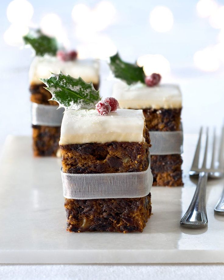 three pieces of cake sitting on top of a white plate next to forks and silverware