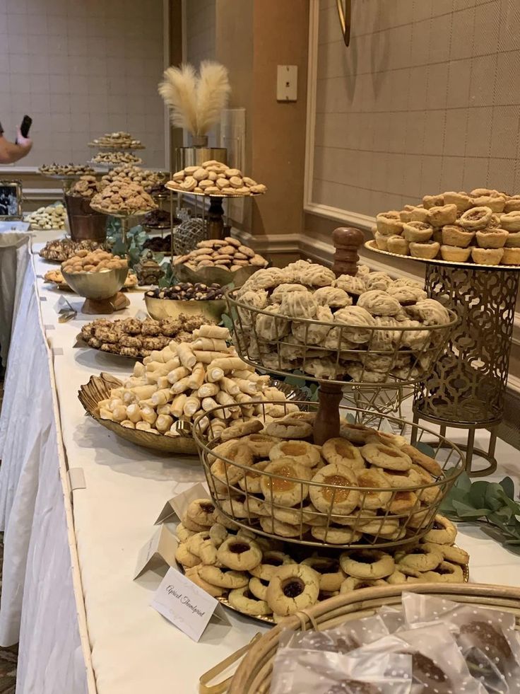 a table topped with lots of pastries on top of a white cloth covered table