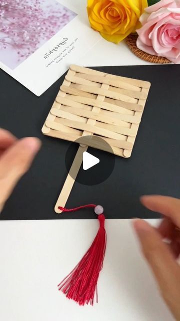 someone is making a craft with popsicle sticks and yarn