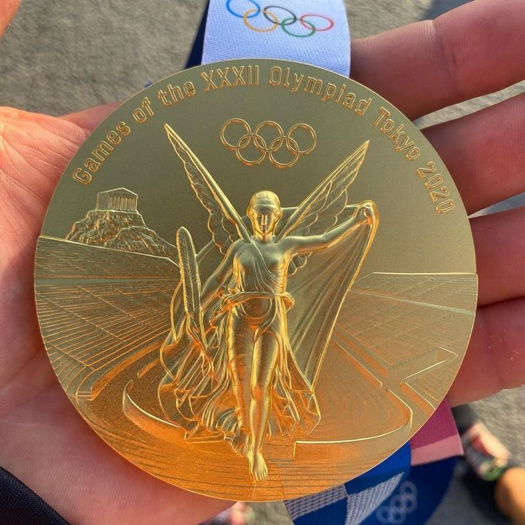 the olympic medal is being held by someone's hand