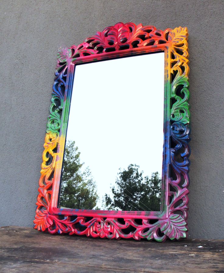 a colorful mirror sitting on top of a wooden table