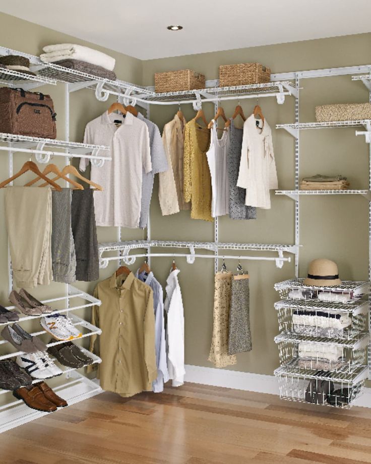 an organized closet with white shelving and lots of clothes hanging on the rails,