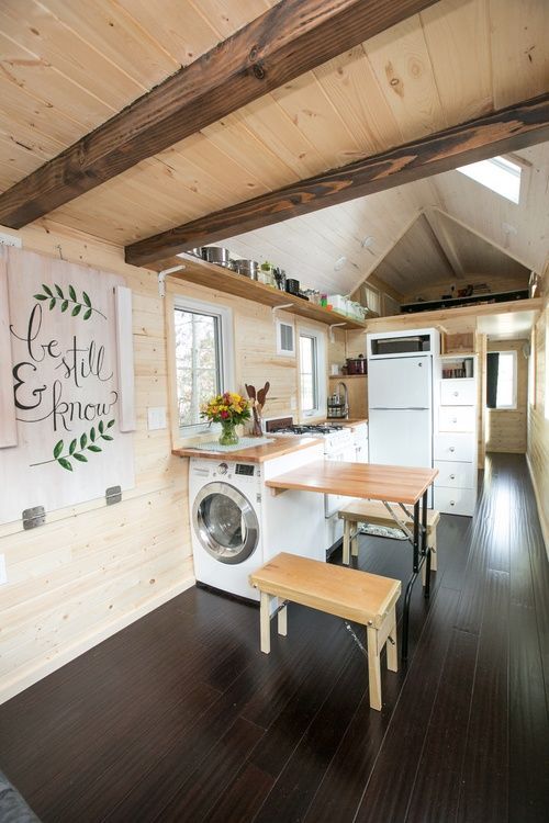 a washer and dryer in a room with wood flooring on the walls