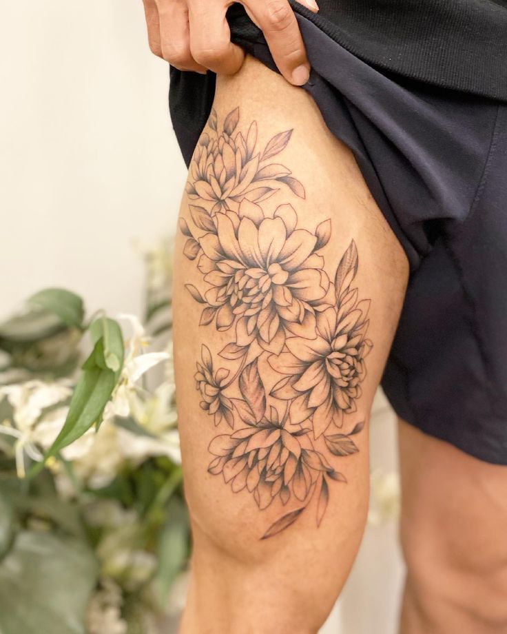 a close up of a person's thigh with flowers on it and the lower half of their leg