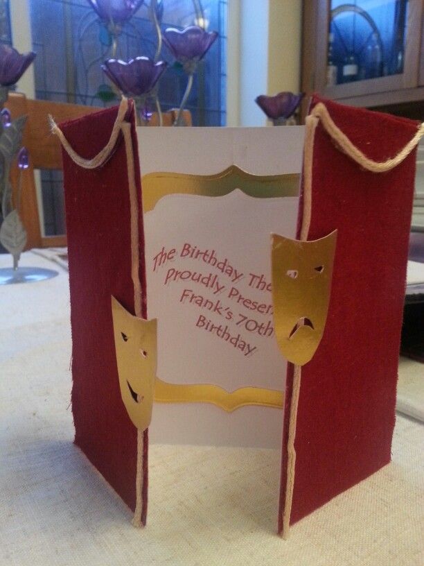 a red and white birthday card on a table with purple flowers in vases behind it