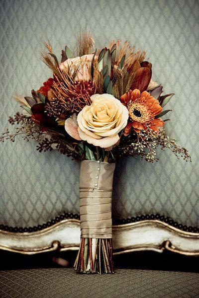 a bouquet of flowers sitting on top of a bed in front of a blue wall