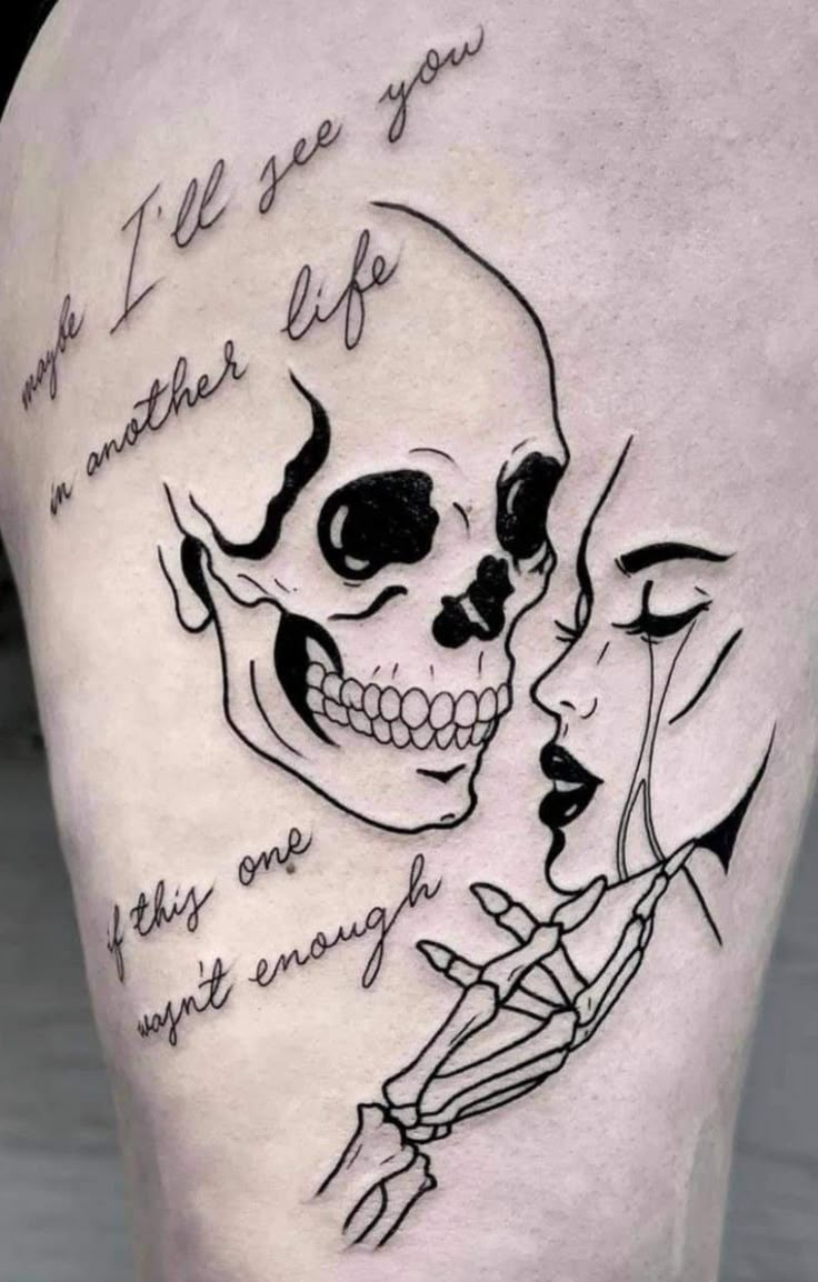 a woman's thigh with a skull and words on it, in black ink