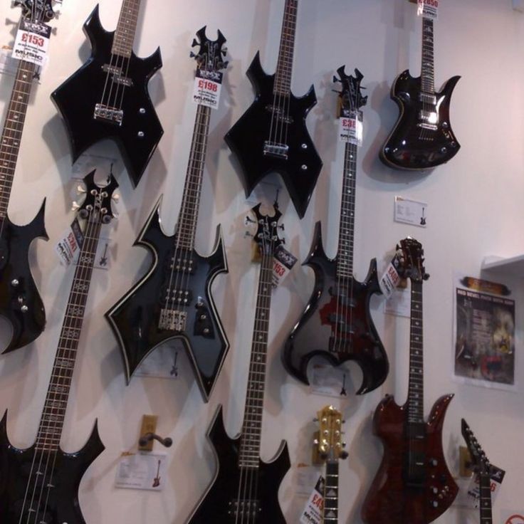 guitars are lined up on the wall for display