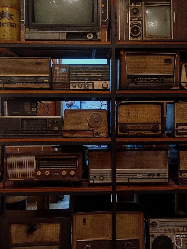 many old radio's are stacked on top of each other