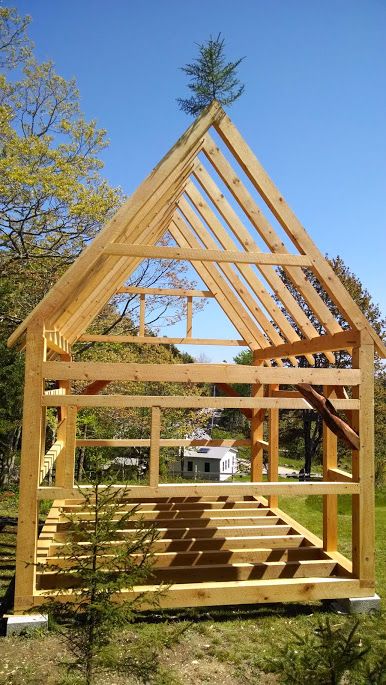 a wooden structure sitting in the middle of a field