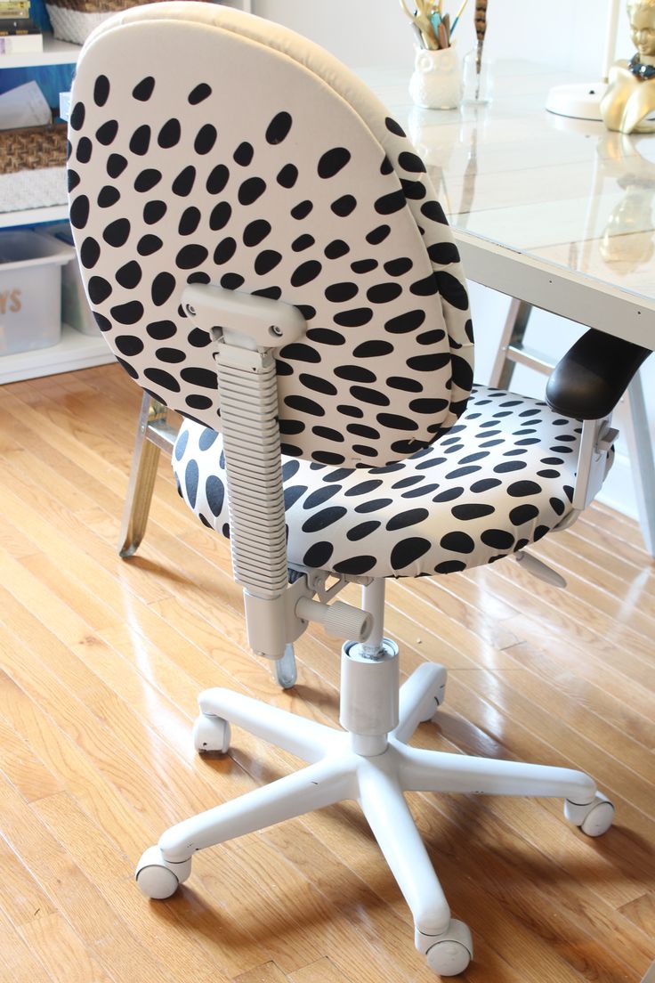 a polka dot office chair sitting on top of a hard wood floor next to a white desk