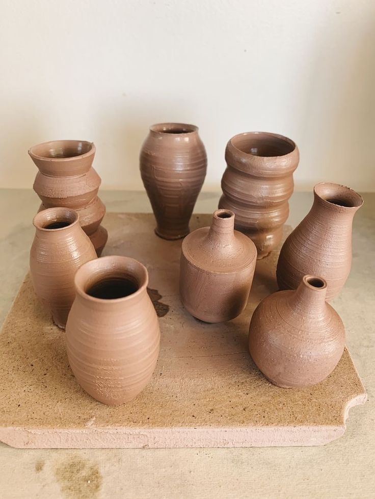 several clay vases are arranged on a table