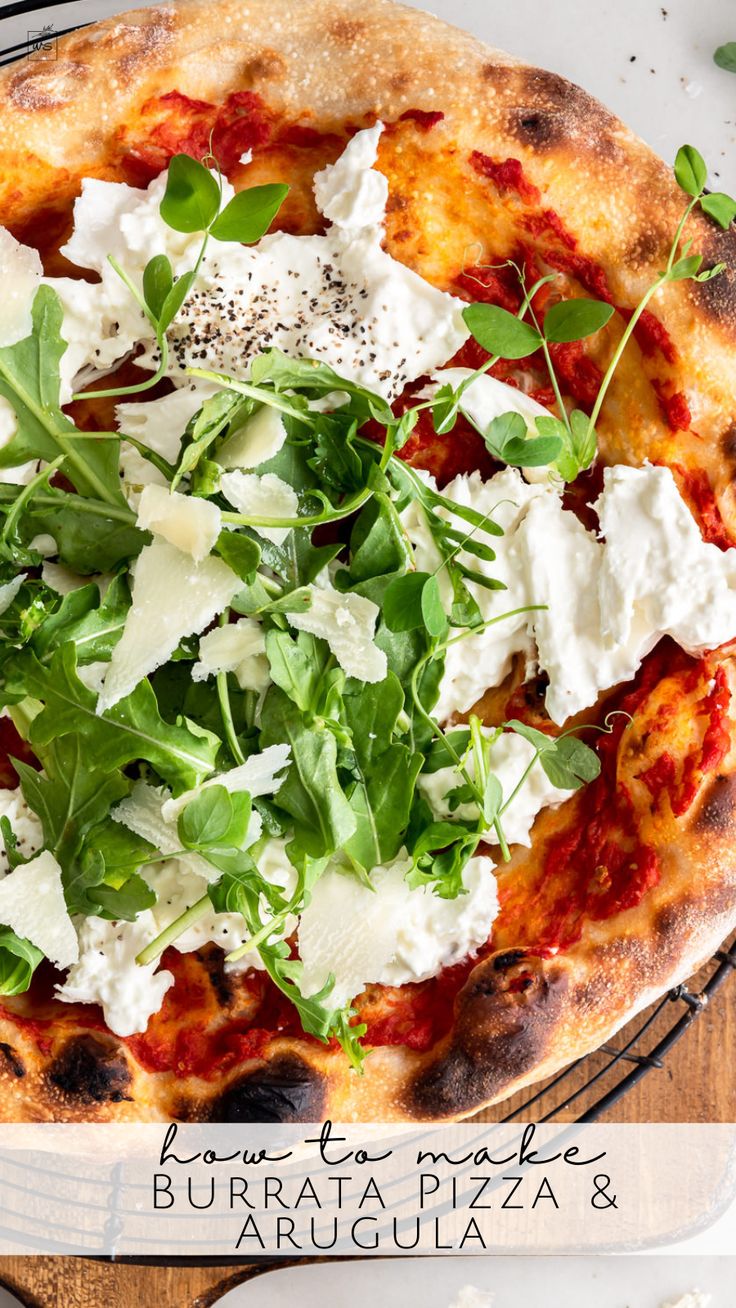 a pizza topped with cheese and greens on top of a wooden cutting board