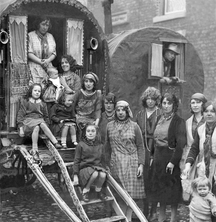 an old black and white photo of people standing in front of a horse drawn carriage