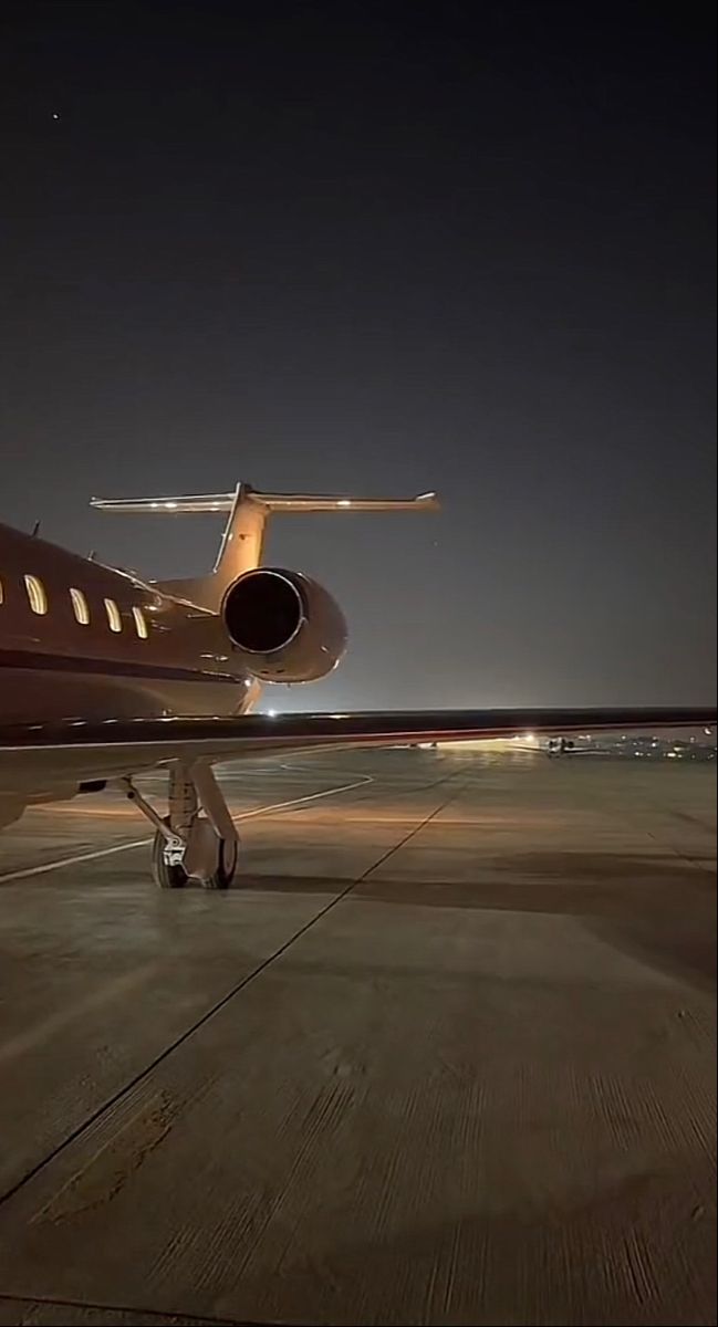 an airplane is sitting on the runway at night