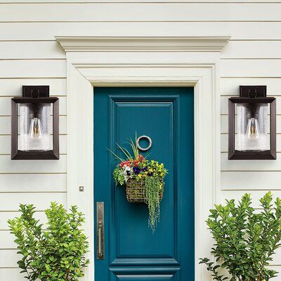 a blue front door with two planters on it