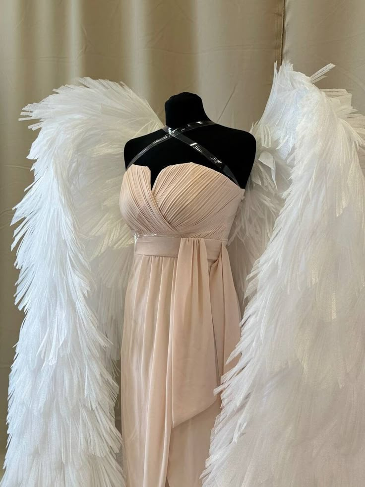 a mannequin dressed in a dress with white wings