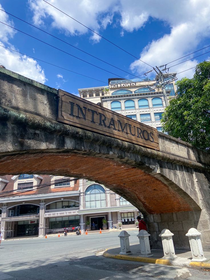 an old stone bridge with the word intra muro on it's side and buildings in the background